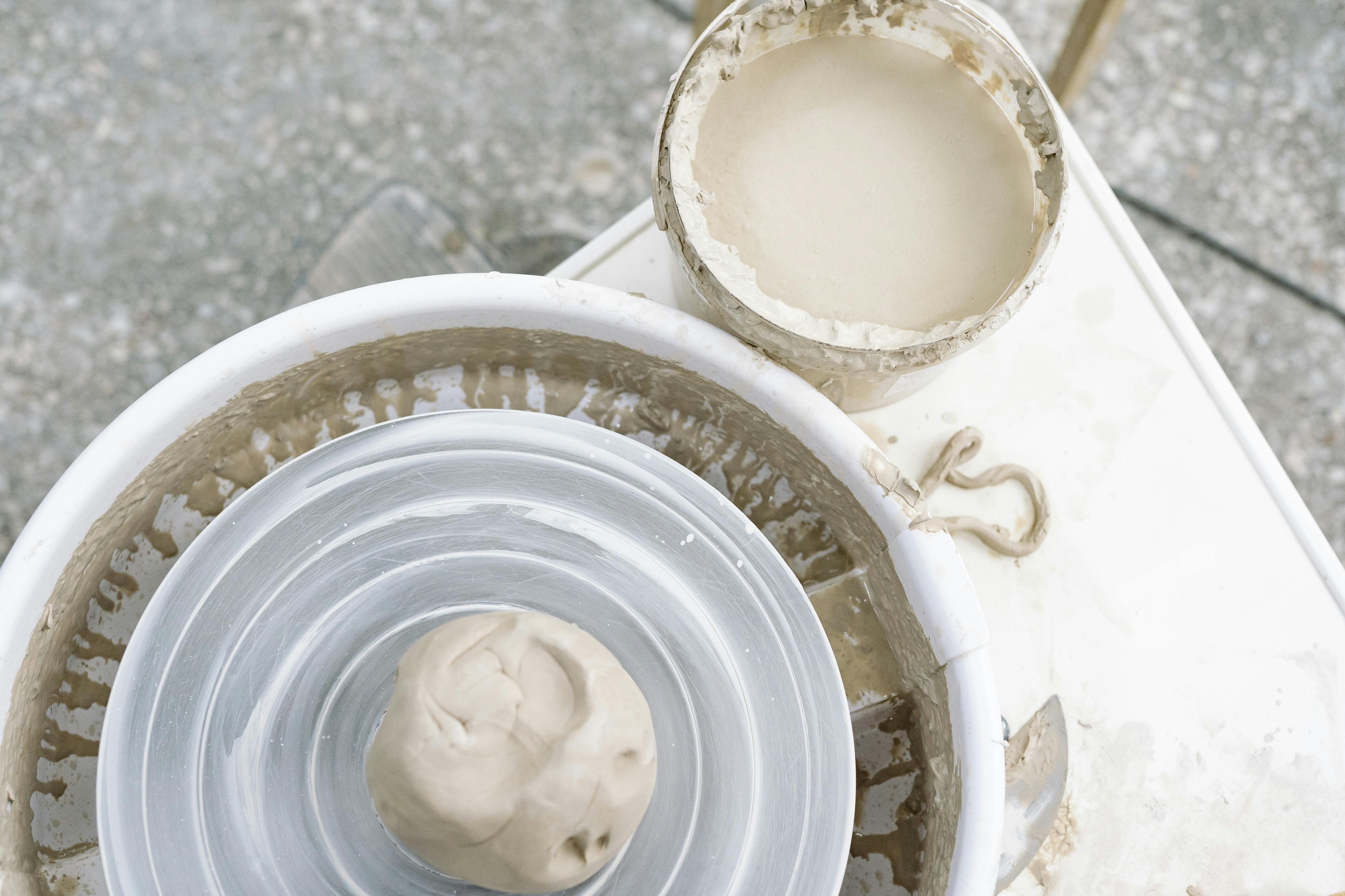 Close-up view of clay being shaped on a pottery wheel, showing the creative process.