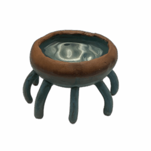 A ceramic bowl featuring six curved legs and a turquoise, glossy interior.