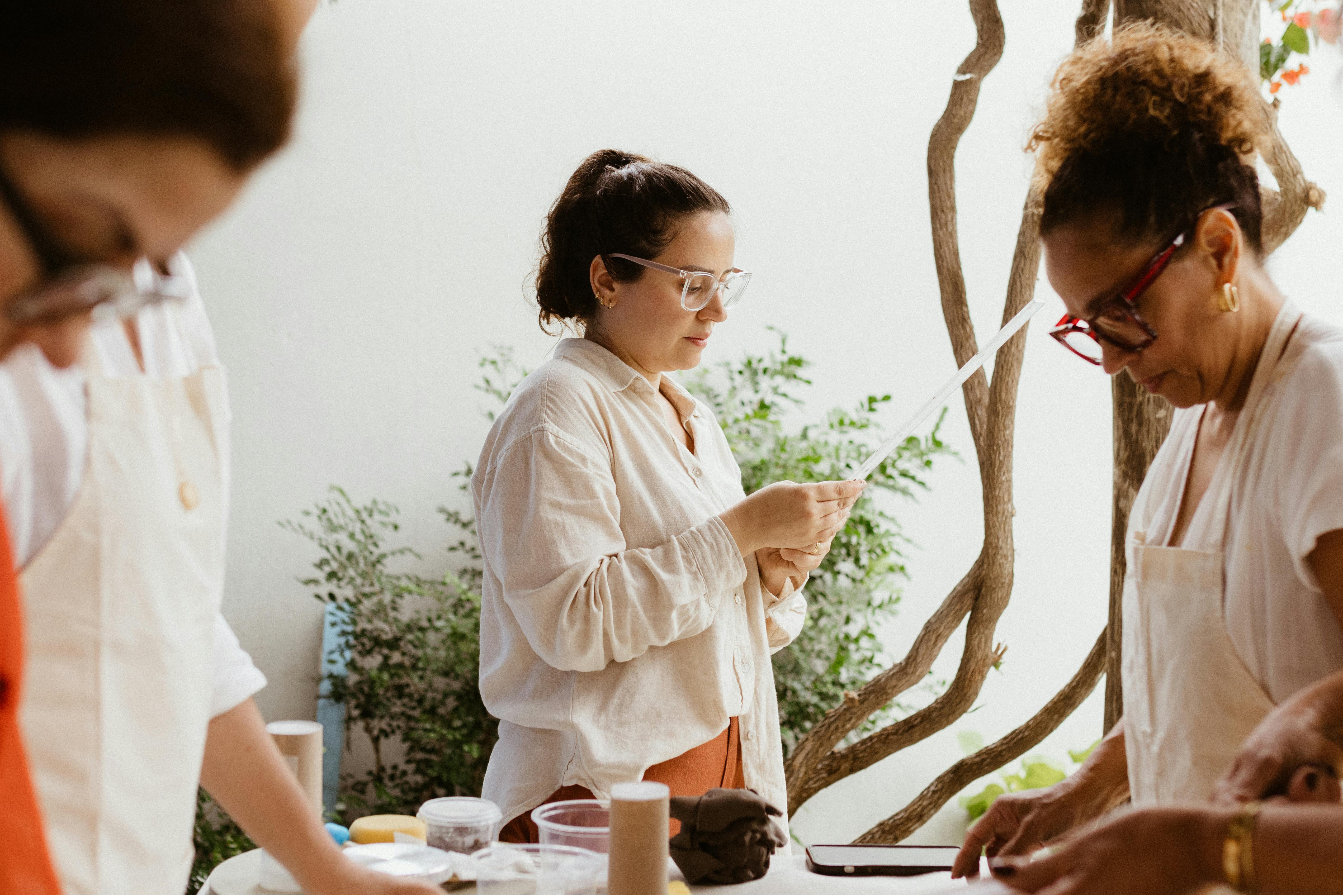 Adults engaged in a creative pottery workshop, crafting and bonding indoors.
