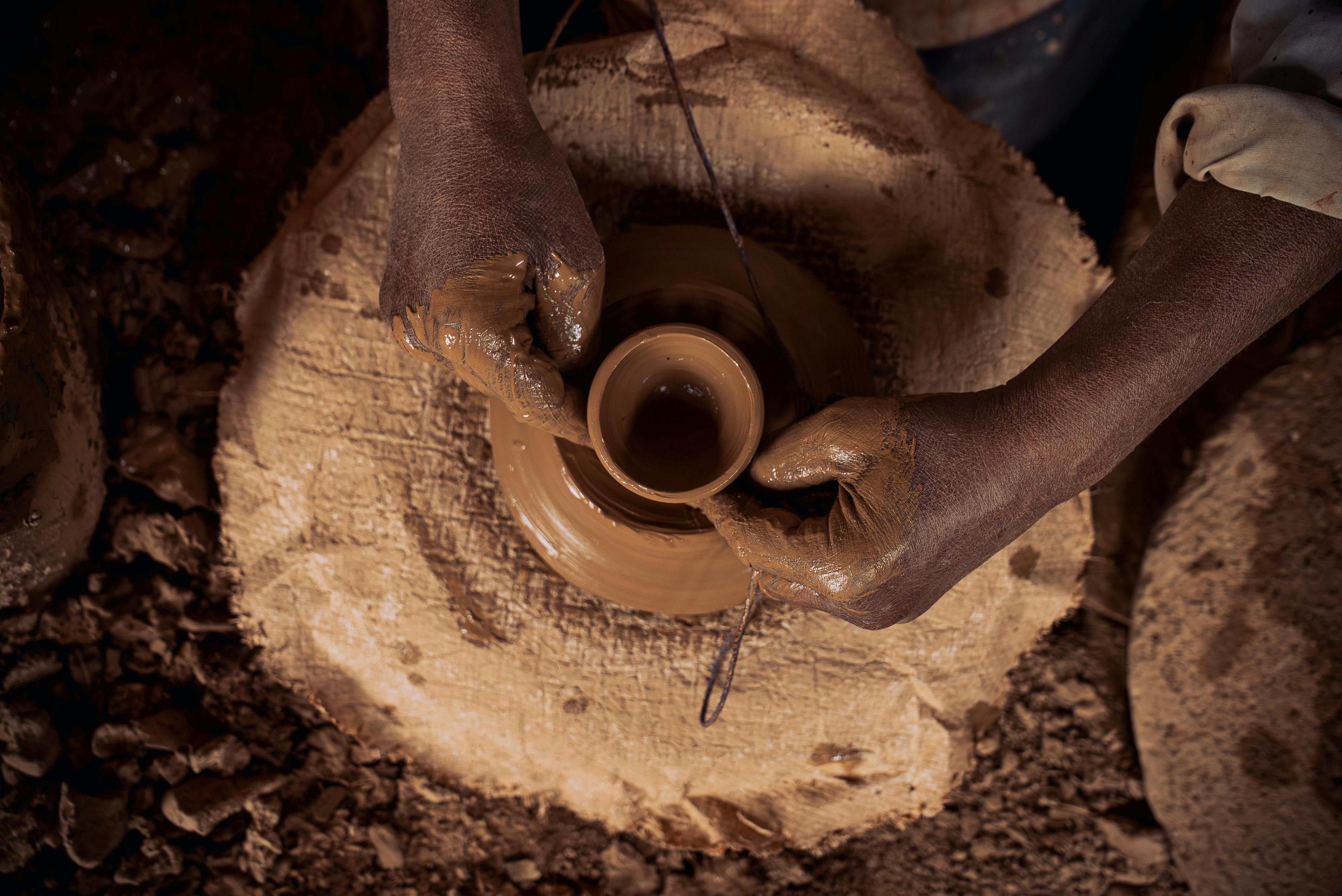 Close-up of hands shaping clay on a potter's wheel in Marrakech, Morocco.