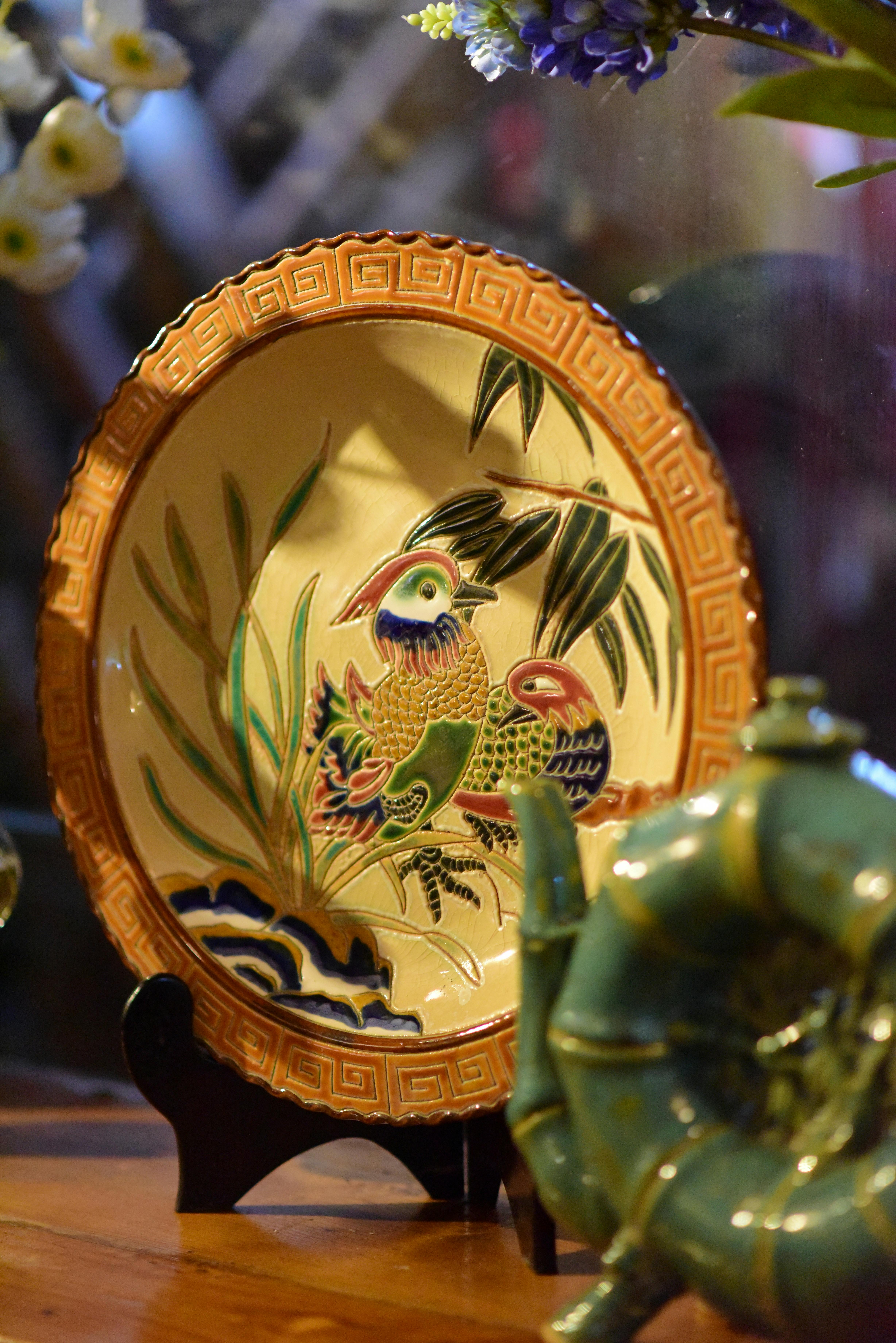 Vibrant ceramic plate featuring a bird motif, ideal for decor or collection display.