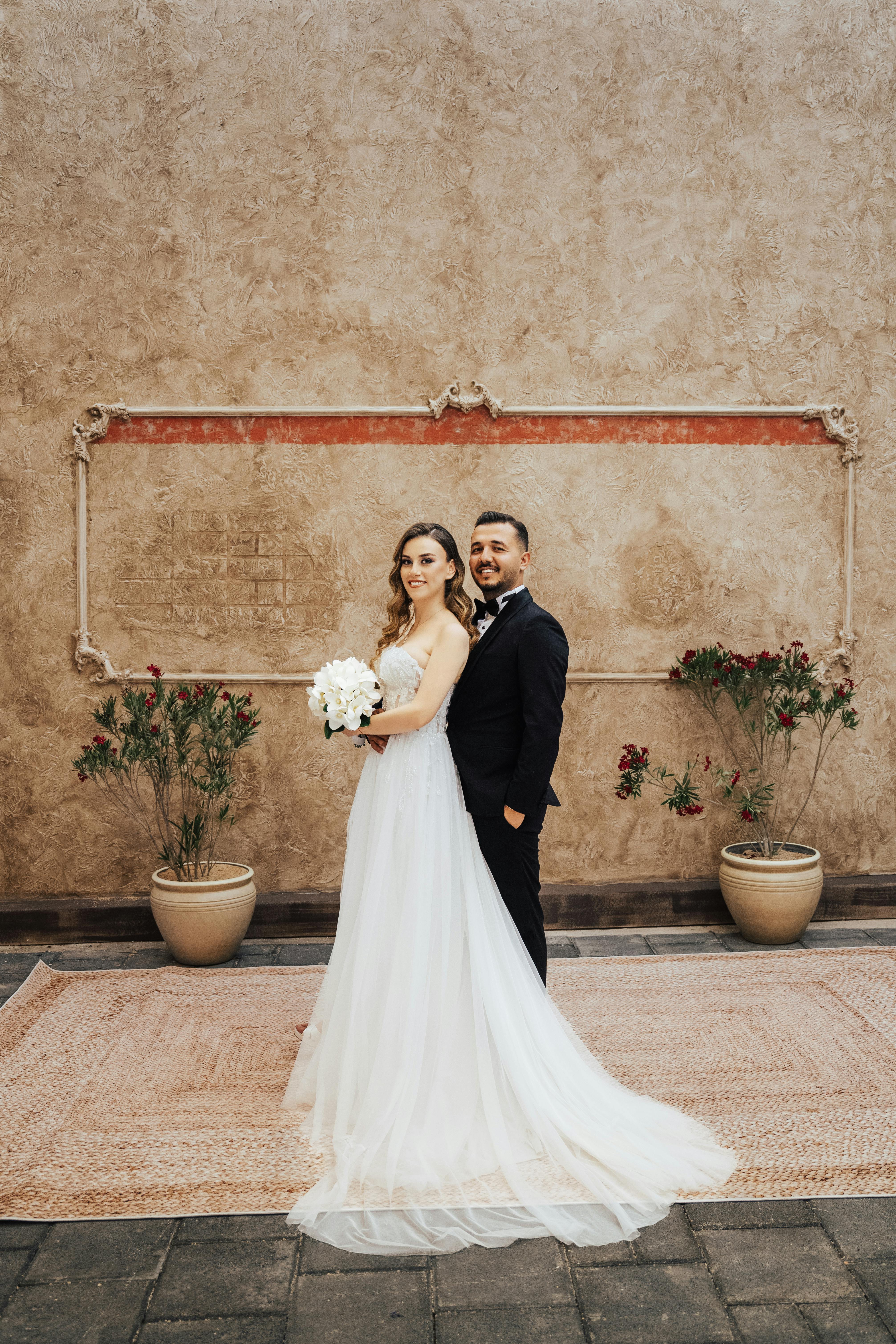 Elegant bride and groom posing outdoors in a charming courtyard setting in Antalya, Türkiye.