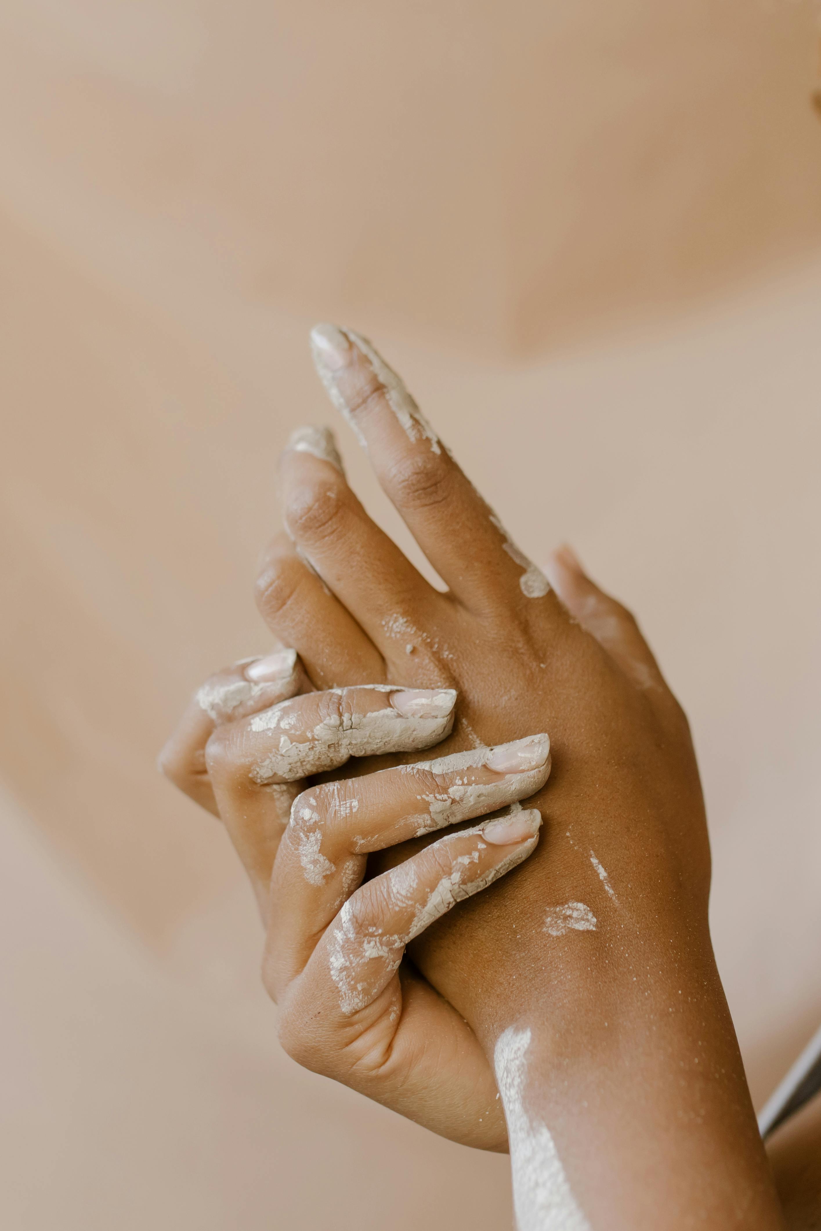 Close-up of hands engaged in artistic clay working, emphasizing the creative process.