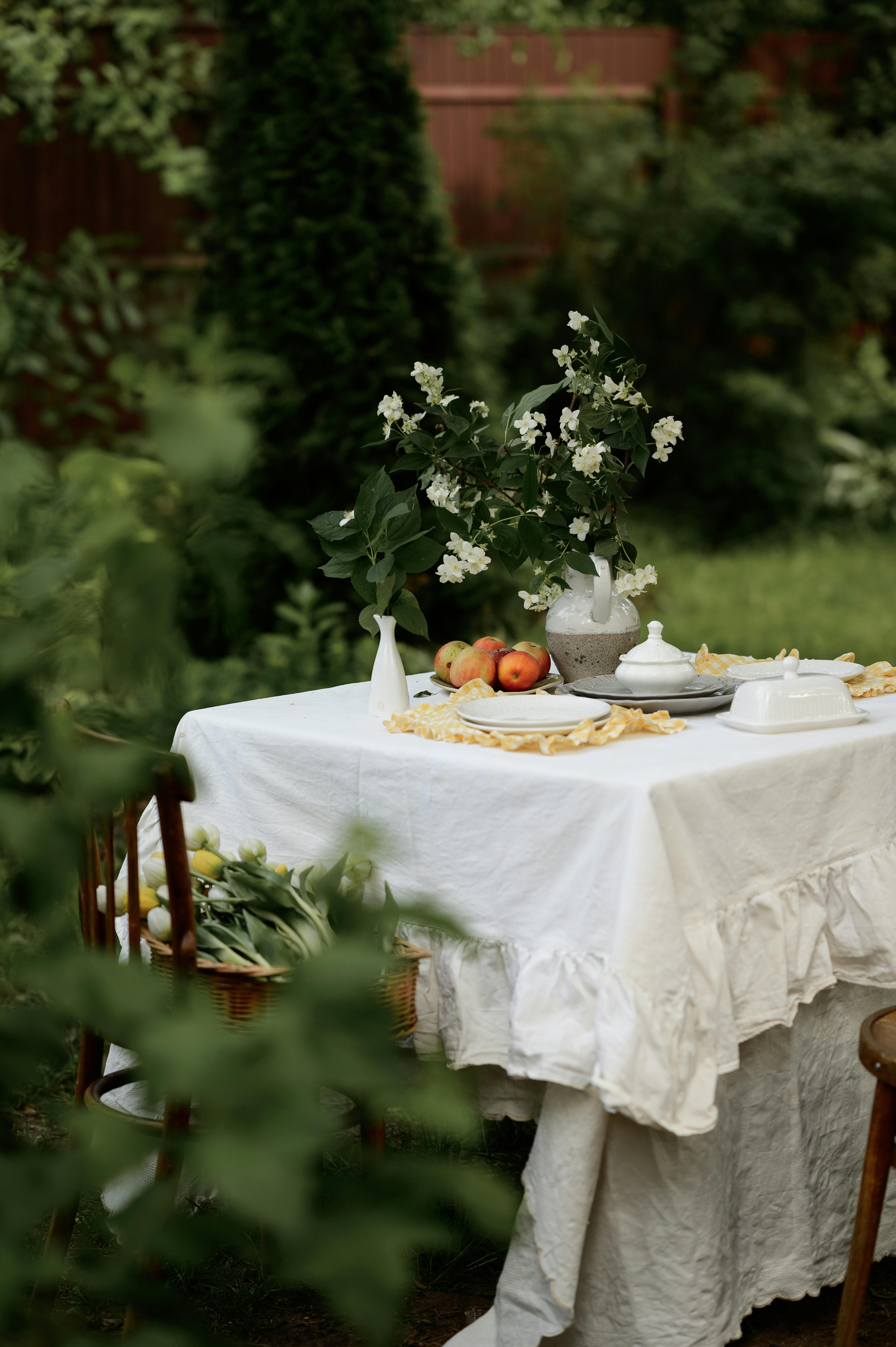 Beautiful outdoor brunch setup with flowers, fruits, and rustic charm.