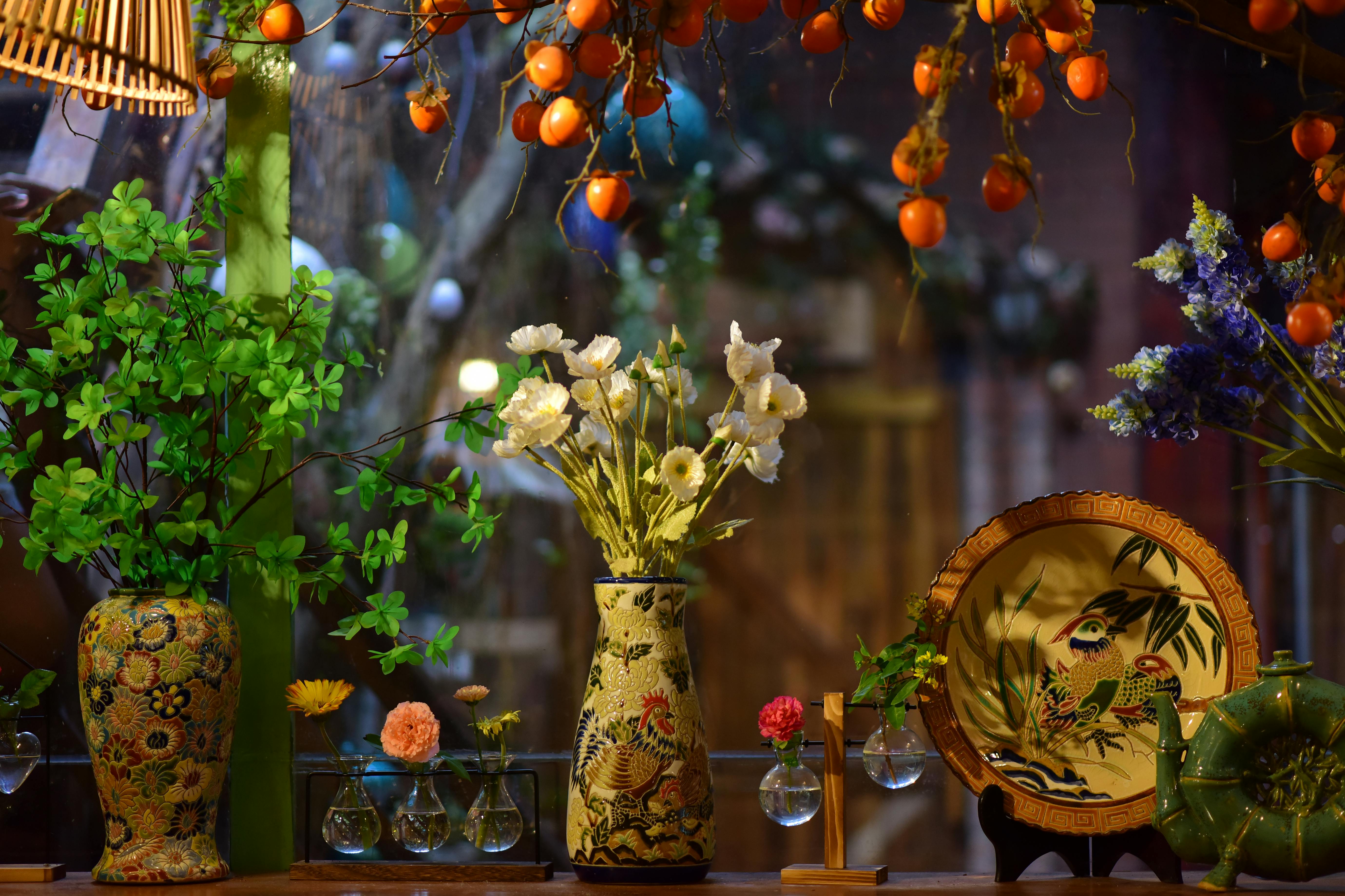 Colorful indoor display with vases, flowers, and decorative dishes, ideal for home decor inspiration.