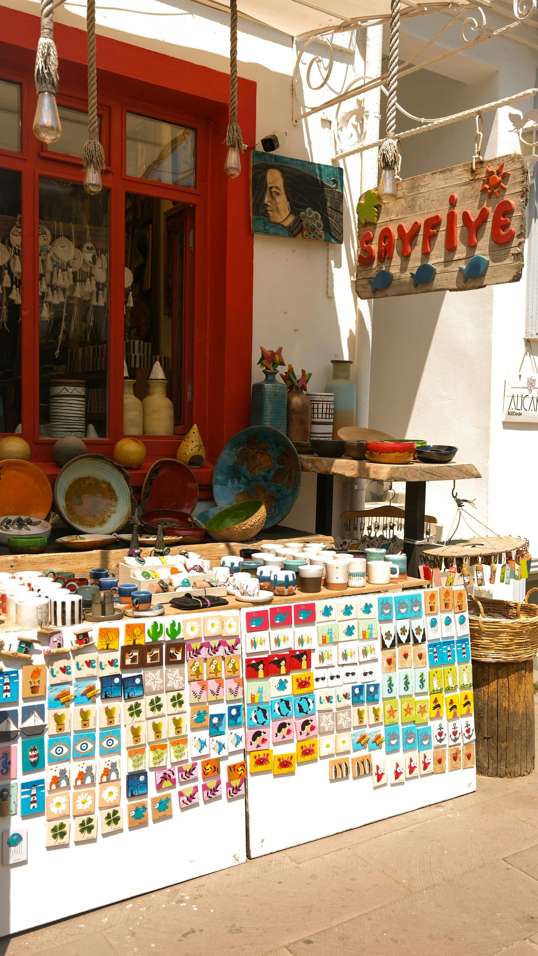 Charming display of colorful local crafts and souvenirs outside a sunlit shop.