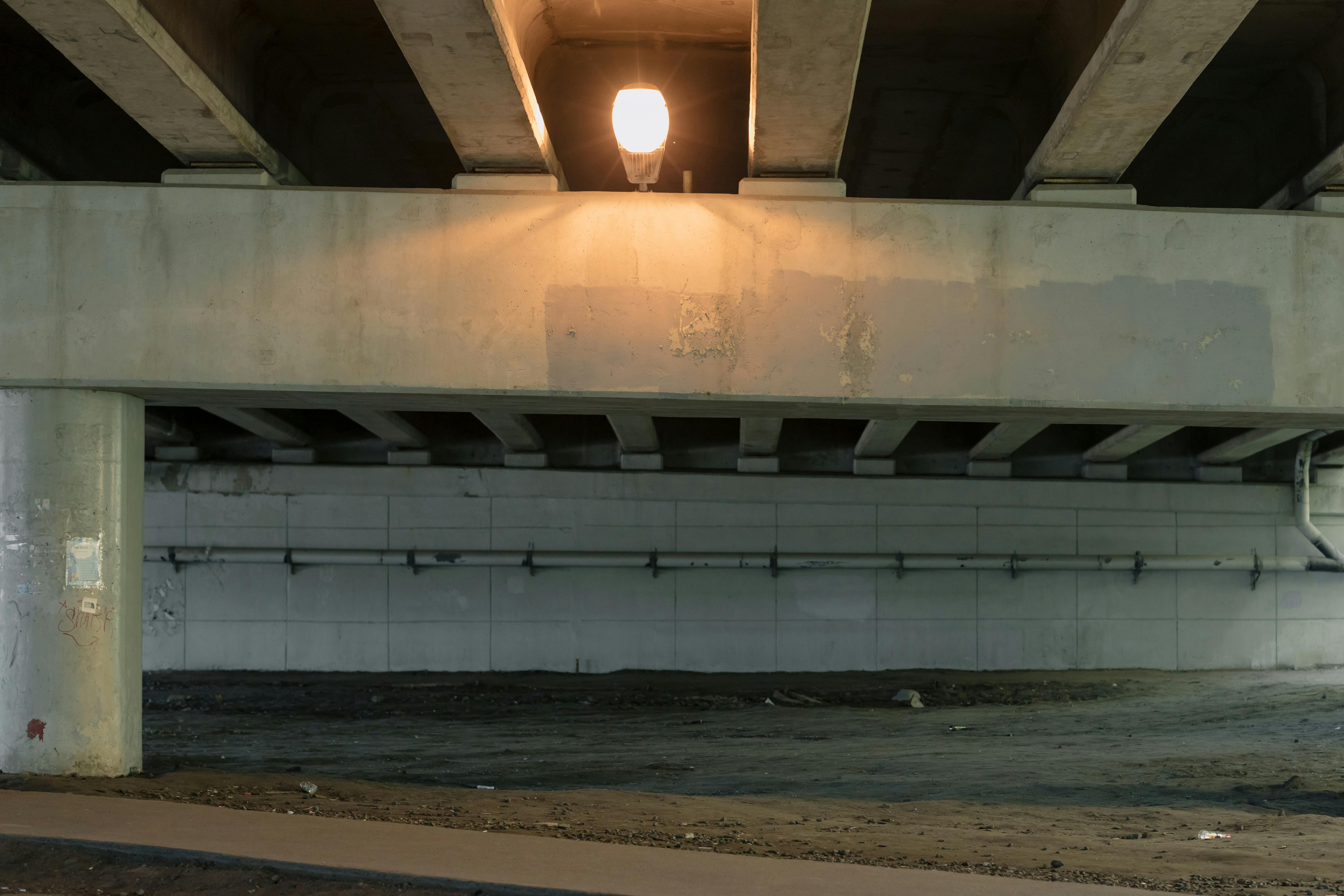 A lit underpass displaying concrete columns and beams.